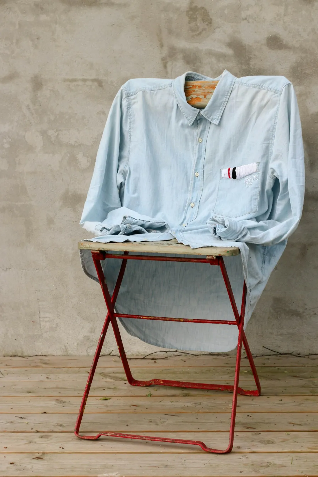 Camisa azul sobre una silla roja en el taller